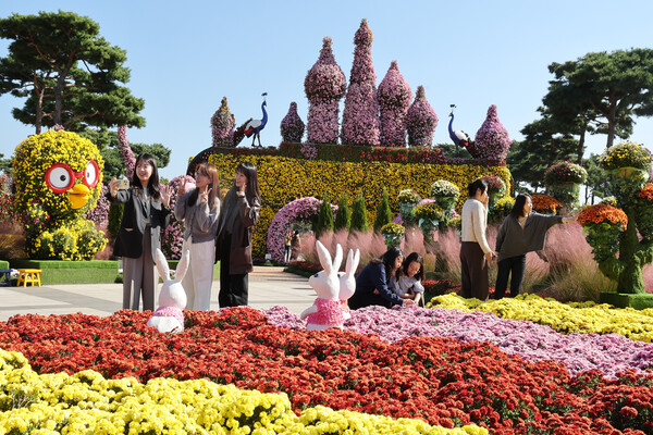 대형 공룡과 사슴 등 국화조형물, 전시컵과 회전목마, 뽀로로 등으로 구성된 중앙광장에서 인생샷을 남기는 관광객들