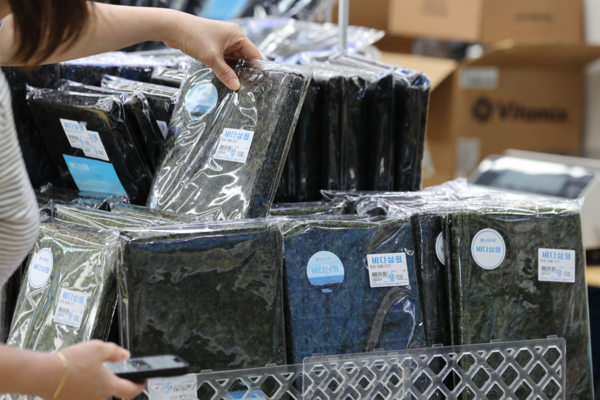 진열대 앞 김을 고르는 손길. 연합뉴스